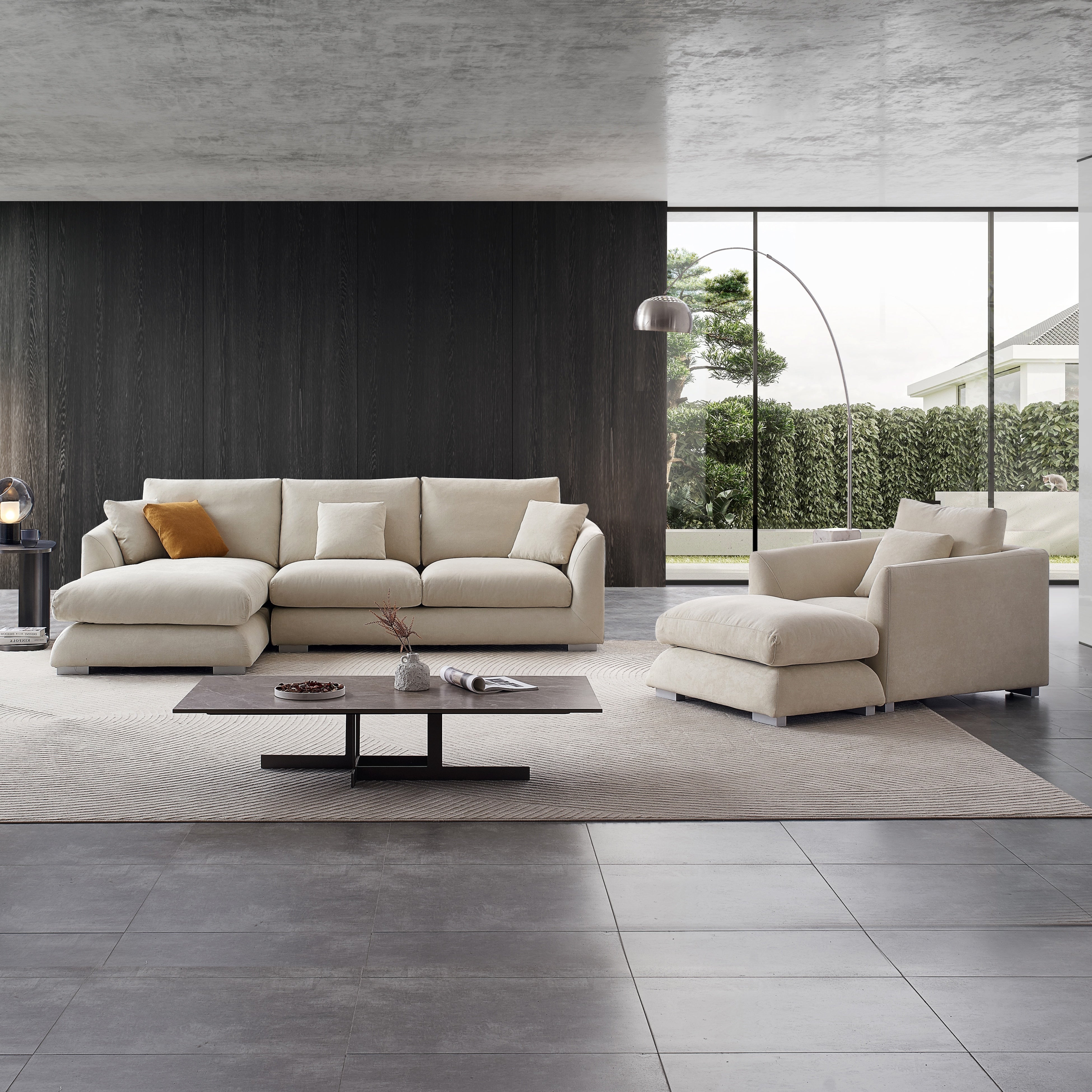 Minimalist living room with an open concept and big glass windows. The focus of the scene is the iconic cloud couch dupe by Mario Capasa. To the right of the Feathers sofa is a single seat and ottoman showing how a modular couch system can improve any living space.