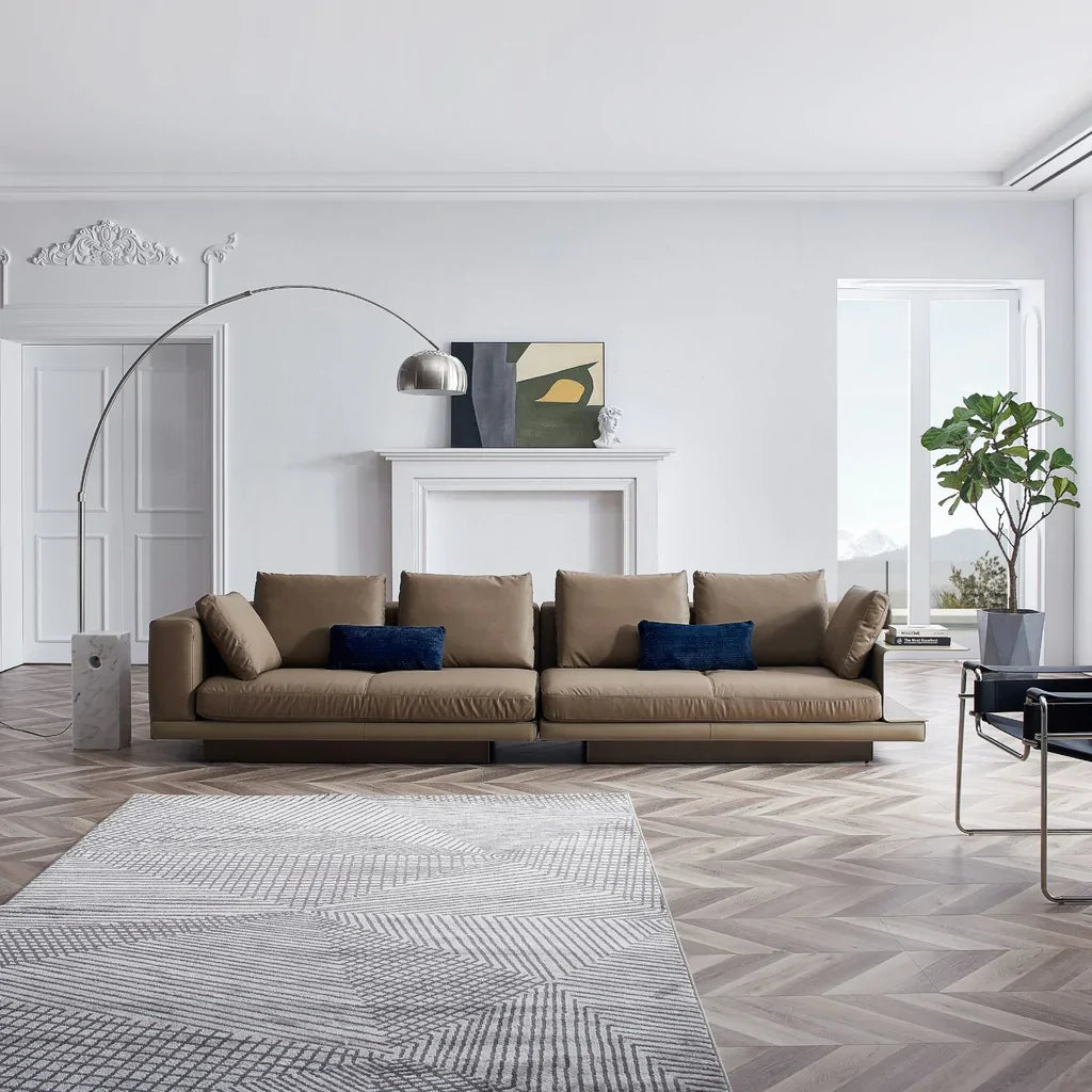 A luxury contemporary living room with white walls and a brown family sofa in the center of the room