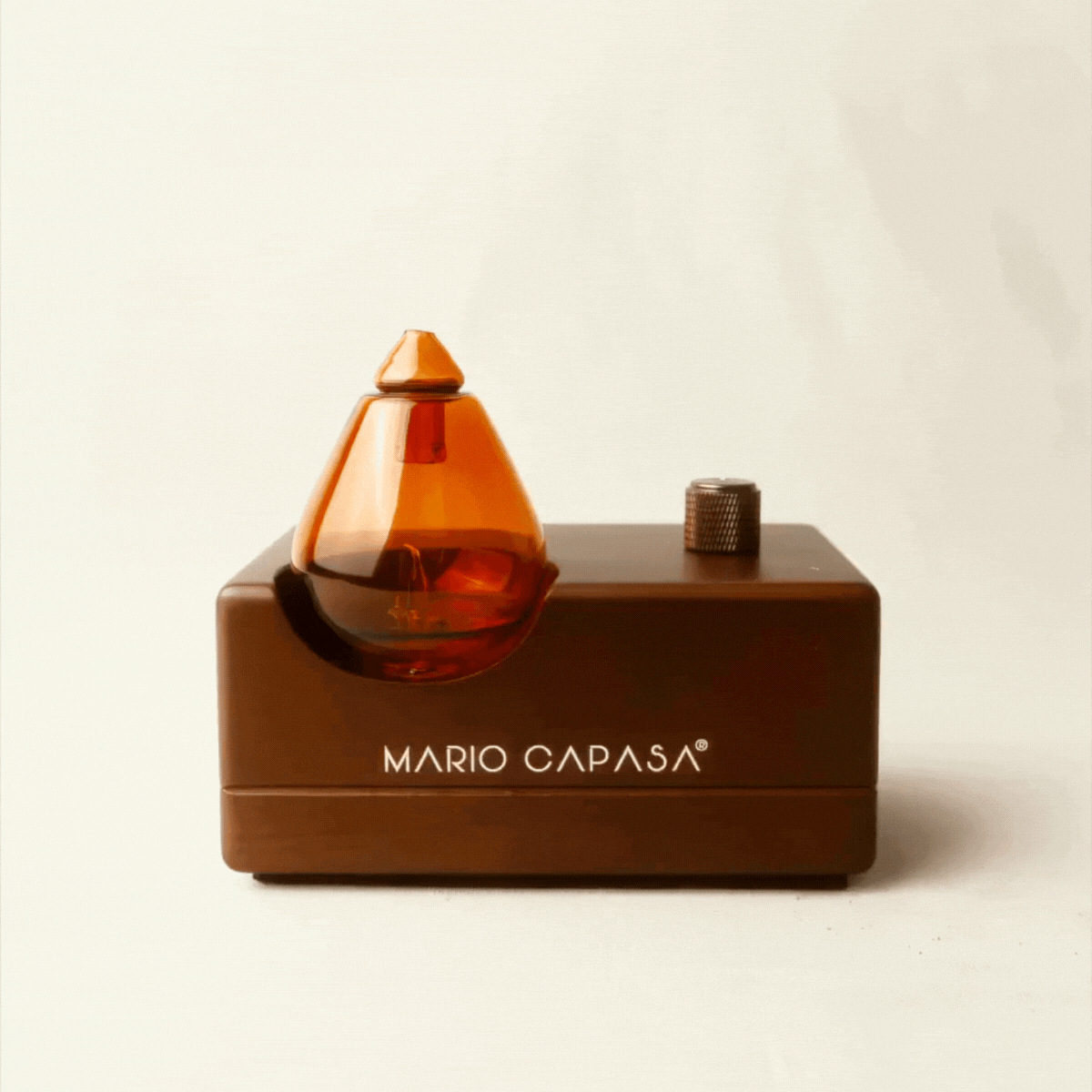 Luxury scent diffuser displayed beside Mario Capasa sofa in serene living room ambiance.